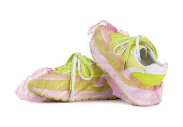 Sneakers in pink shoe covers isolated on white