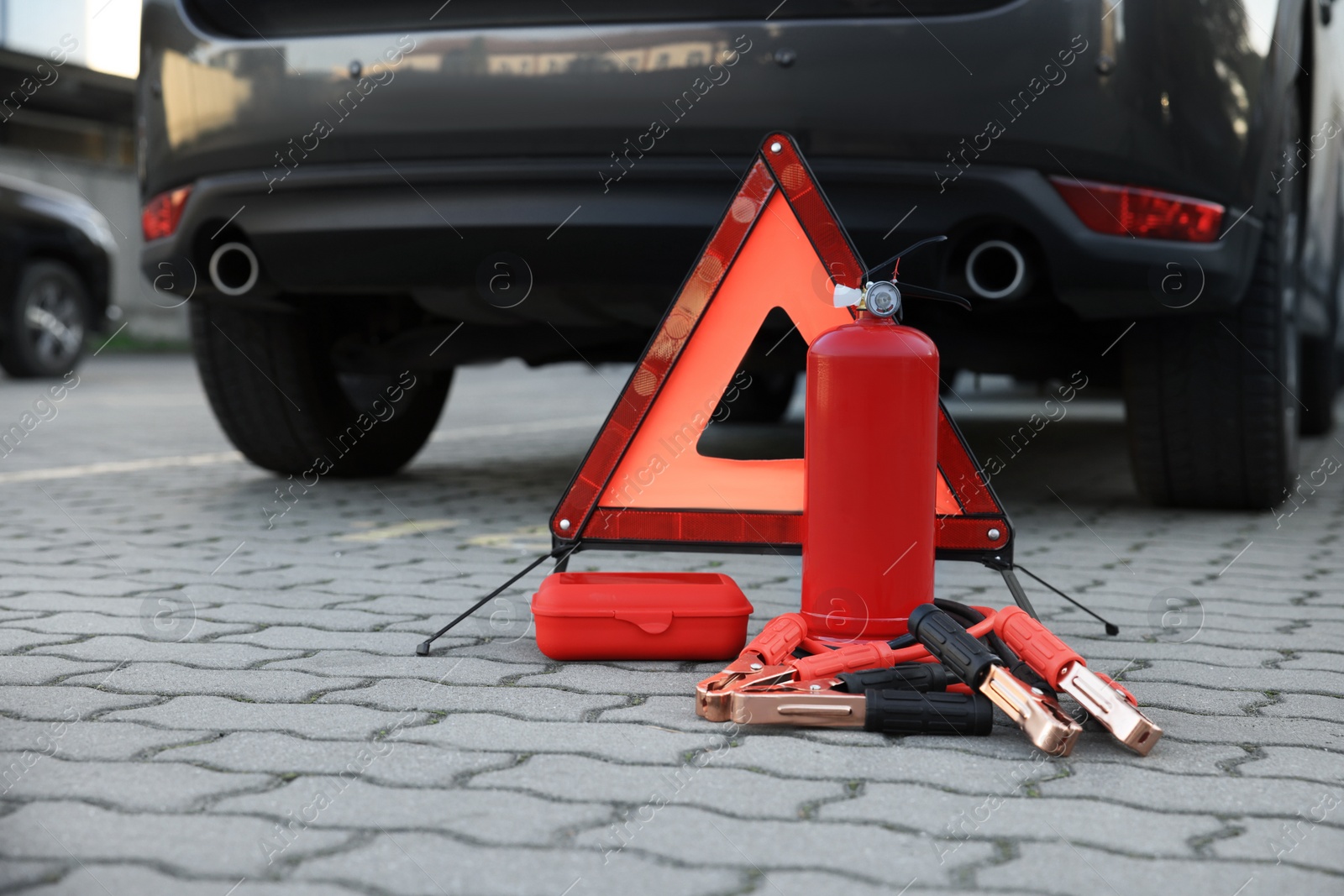 Photo of Emergency warning triangle and safety equipment near car, space for text