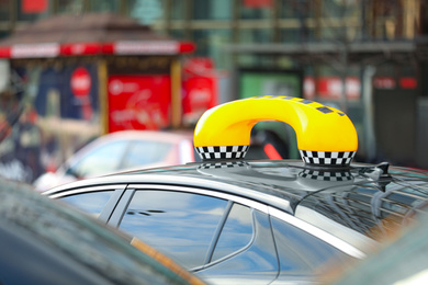 Photo of Taxi cab with yellow sign on city street, closeup