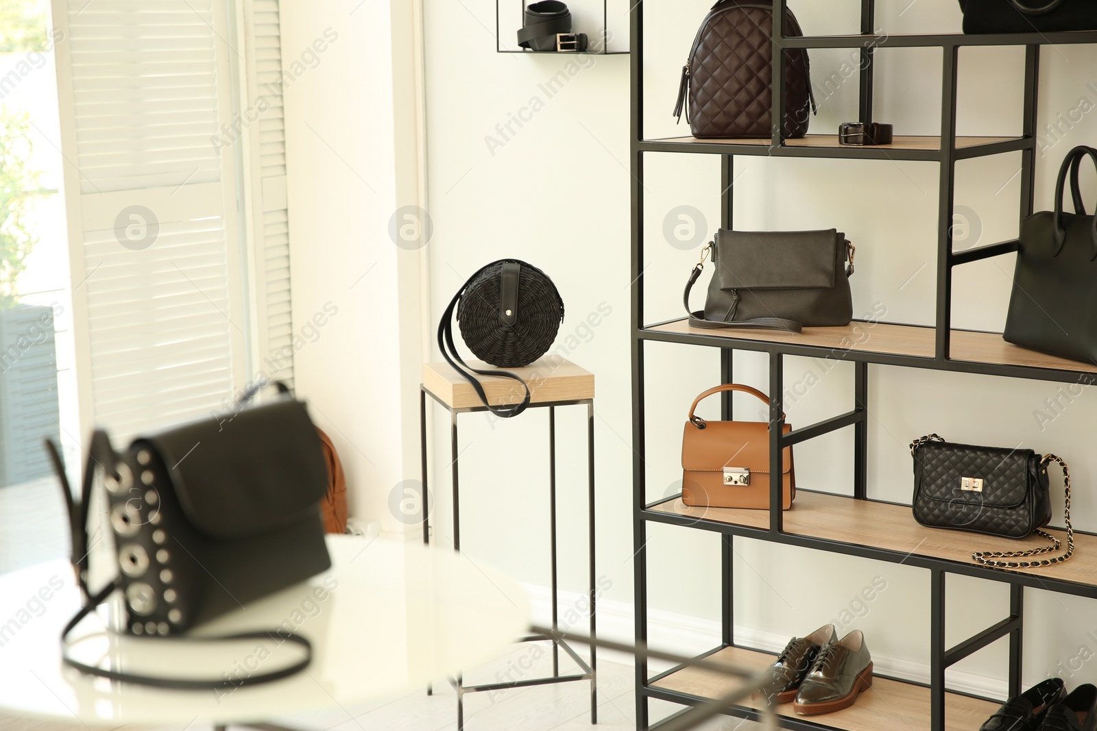 Photo of Stylish woman's bags on shelves in boutique