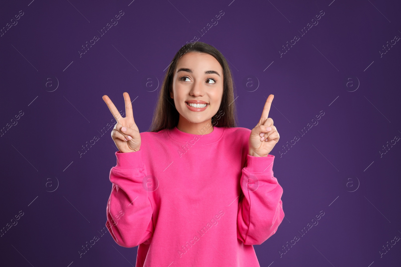 Photo of Woman showing number three with her hands on purple background