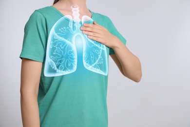 Image of Woman holding hand near chest with illustration of lungs on light grey background, closeup