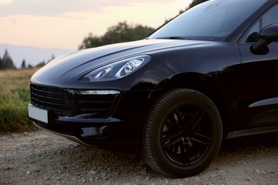 Photo of Modern black car parked on roadside outdoors