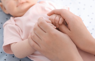 Photo of Mother with her cute little baby in crib, closeup