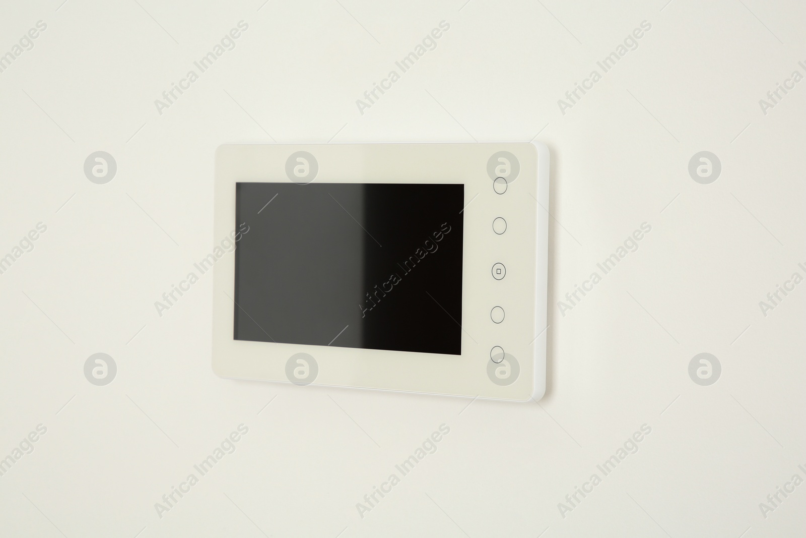 Photo of Modern video intercom hanging on white wall