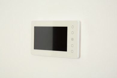 Modern video intercom hanging on white wall