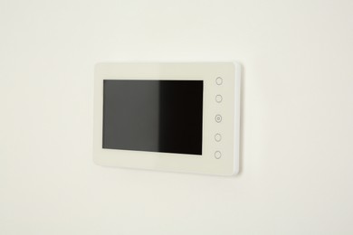 Photo of Modern video intercom hanging on white wall