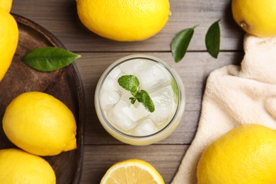 Cool freshly made lemonade and fruits on wooden table, flat lay