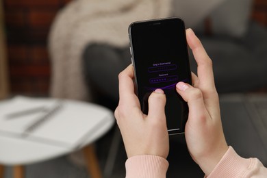 Woman unlocking smartphone with blocked screen indoors, closeup. Space for text