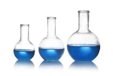 Photo of Florence flasks with liquid samples on white background. Chemistry glassware