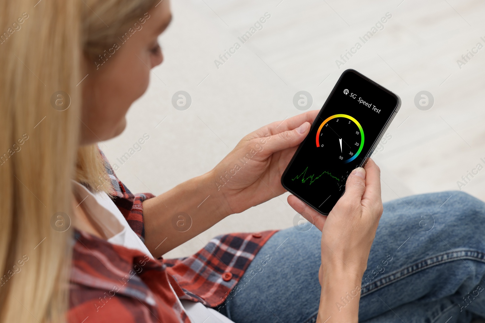 Image of 5G speed test. Woman using mobile phone at home, closeup