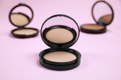 Photo of Face powder with mirror on pink background. Decorative cosmetic
