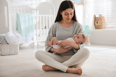 Photo of Young woman with her cute baby at home