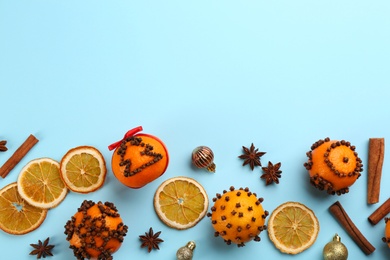 Flat lay composition with pomander balls made of fresh tangerines on light blue background. Space for text