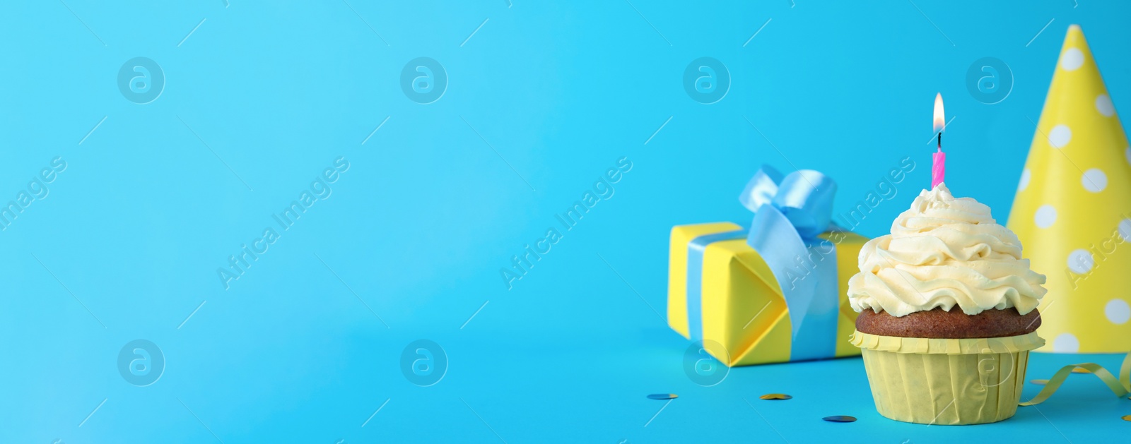 Image of Delicious birthday cupcake with candle on turquoise background, space for text. Banner design