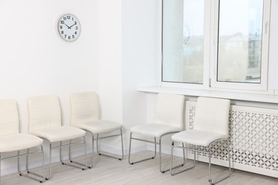 Photo of Many chairs near white wall in waiting area indoors