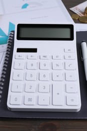 Photo of Calculator and notebook on table, closeup. Pension planning