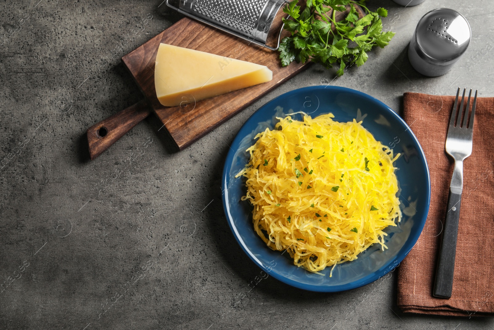 Photo of Flat lay composition with cooked spaghetti squash and space for text on grey table