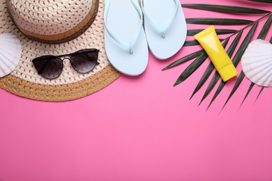 Photo of Flat lay composition with sunscreen and beach accessories on pink background. Space for text