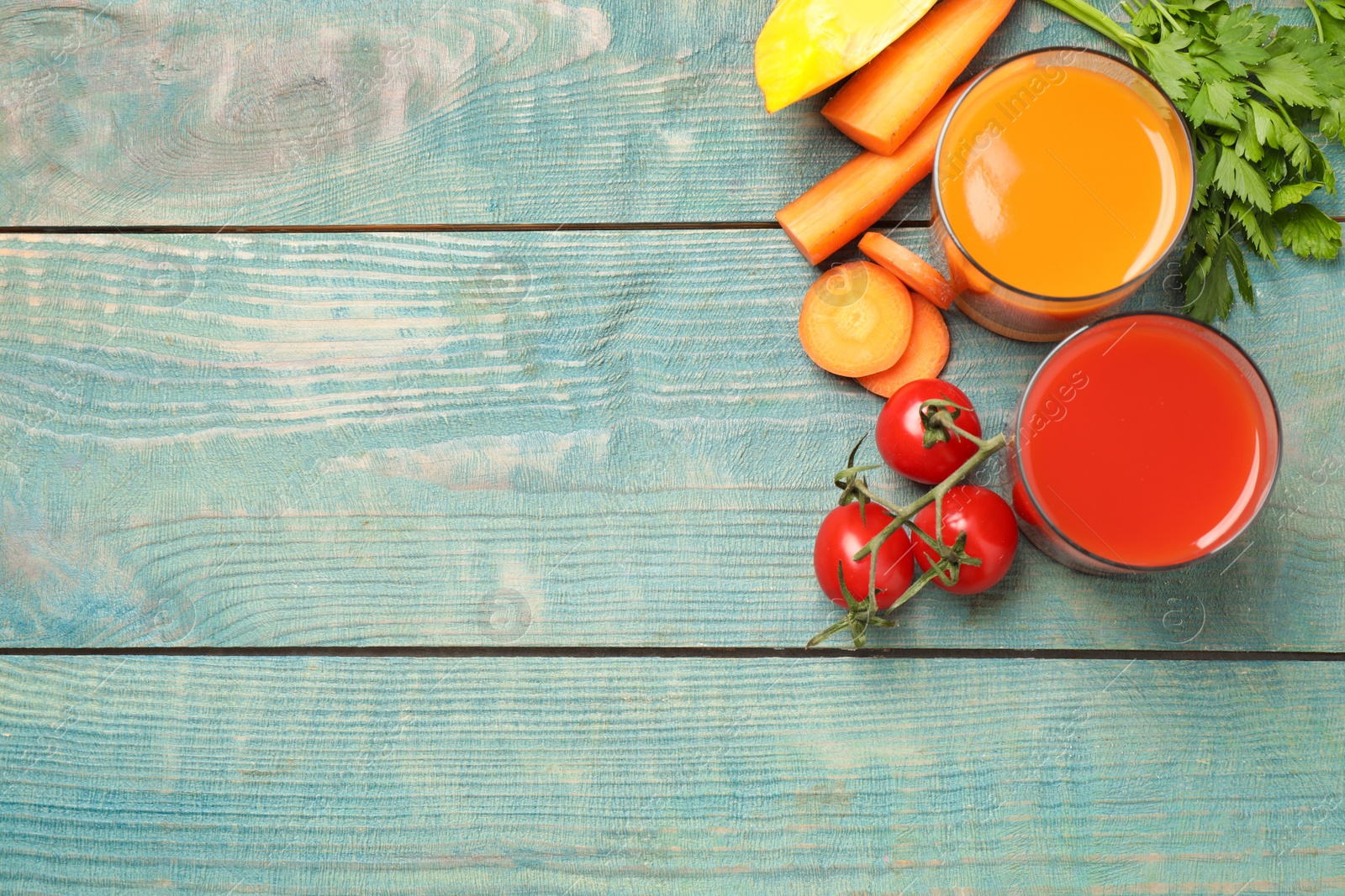 Photo of Delicious vegetable juices and fresh ingredients on blue wooden table, flat lay. Space for text