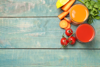 Photo of Delicious vegetable juices and fresh ingredients on blue wooden table, flat lay. Space for text
