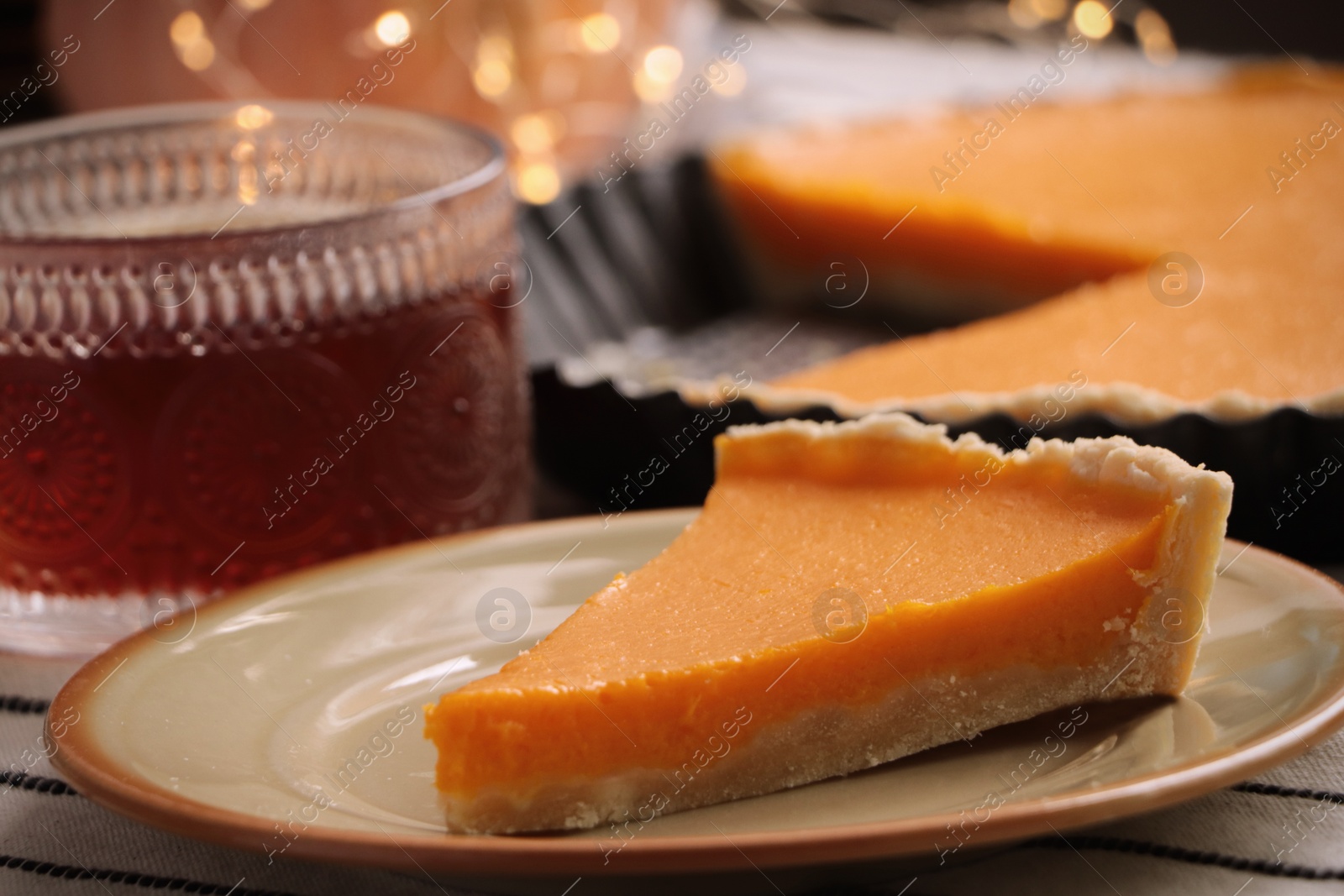 Photo of Piece of fresh homemade pumpkin pie served with tea on table