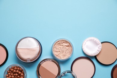 Different face powders on light blue background, flat lay. Space for text