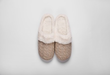 Pair of beautiful soft slippers on white background, top view