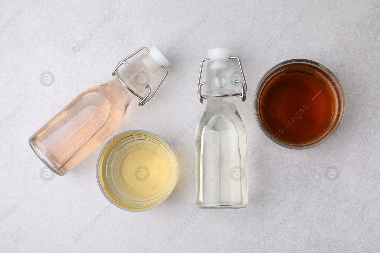 Photo of Different types of vinegar on light table, flat lay