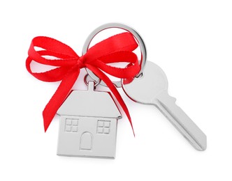 Key with keychain in shape of house and red bow isolated on white, top view