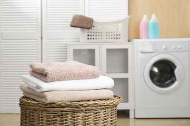 Fresh towels on wicker basket in laundry room