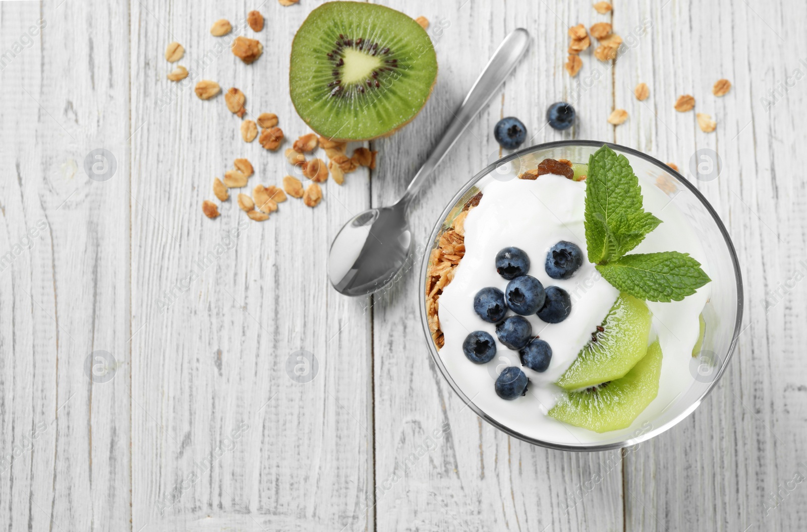 Photo of Healthy homemade granola dessert on white wooden table, flat lay. Space for text