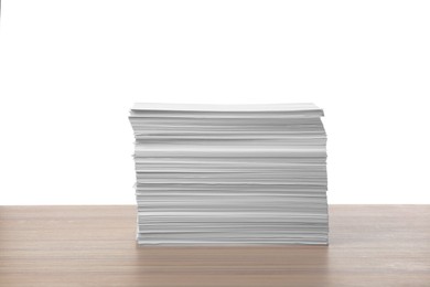 Photo of Stack of paper sheets on wooden table against white background