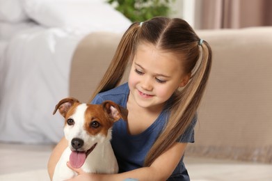 Cute girl with her dog at home. Adorable pet