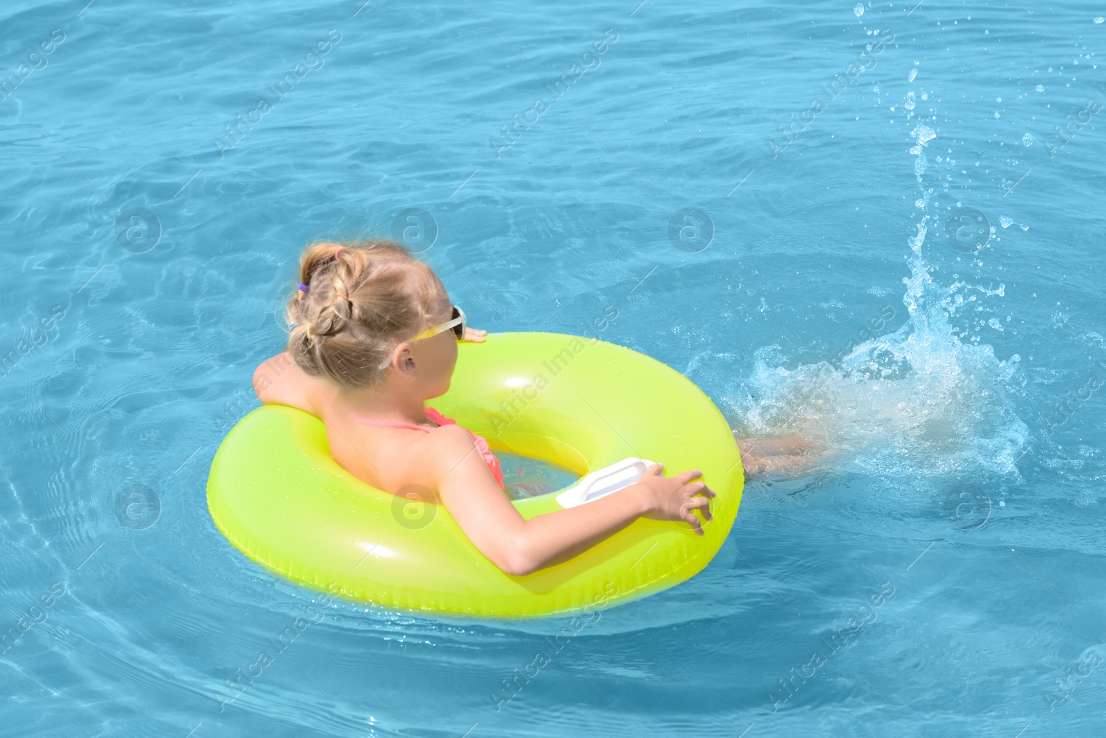 Photo of Little girl with inflatable ring in sea on sunny day