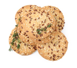 Photo of Round cereal crackers with flax, sunflower, sesame seeds and thyme isolated on white, above view