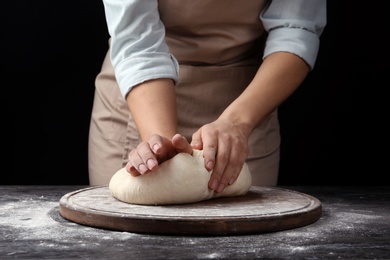 Female baker preparing bread dough at table, closeup