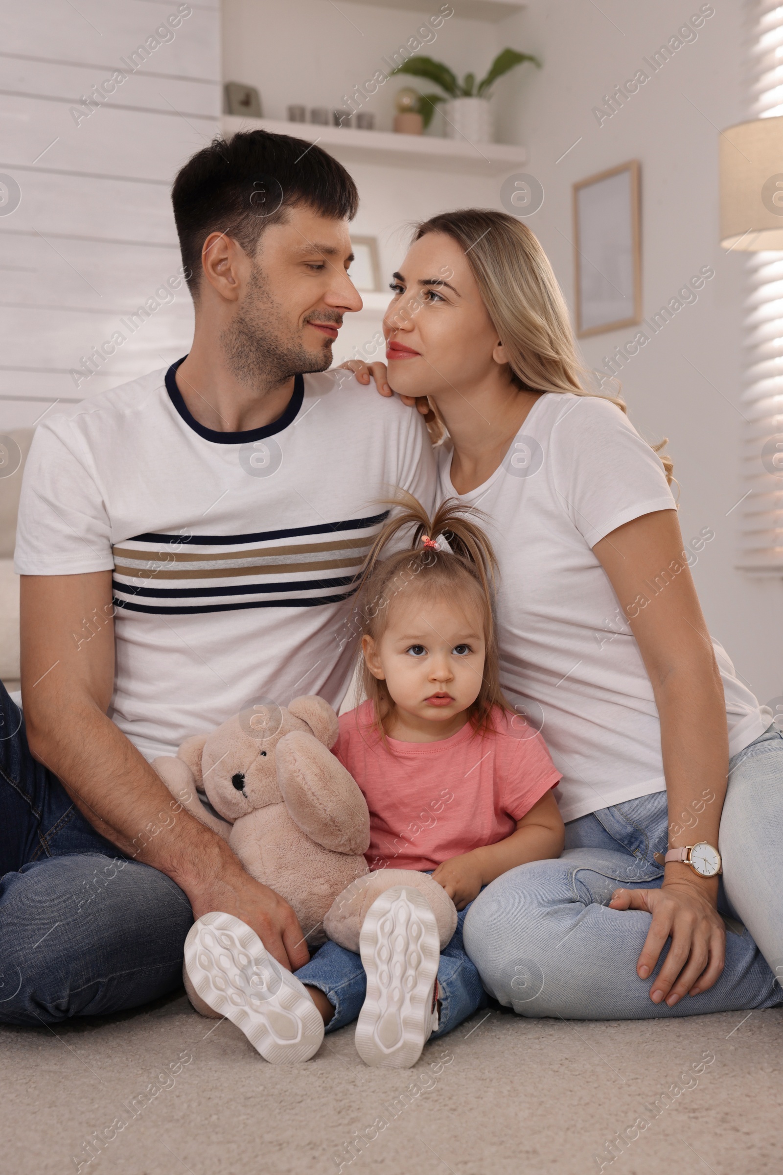 Photo of Family with little daughter spending time together at home