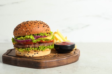 Photo of Burger with delicious patty, french fries and sauce on light table, space for text