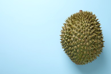 Photo of Fresh ripe durian on light blue background, top view. Space for text