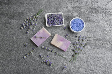 Flat lay composition with hand made soap bars and lavender flowers on grey stone table