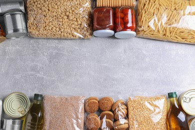 Photo of Different products on light grey table, flat lay with space for text. Food donation