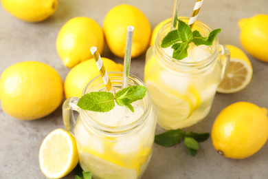 Photo of Natural freshly made lemonade and mint on light grey table. Summer refreshing drink