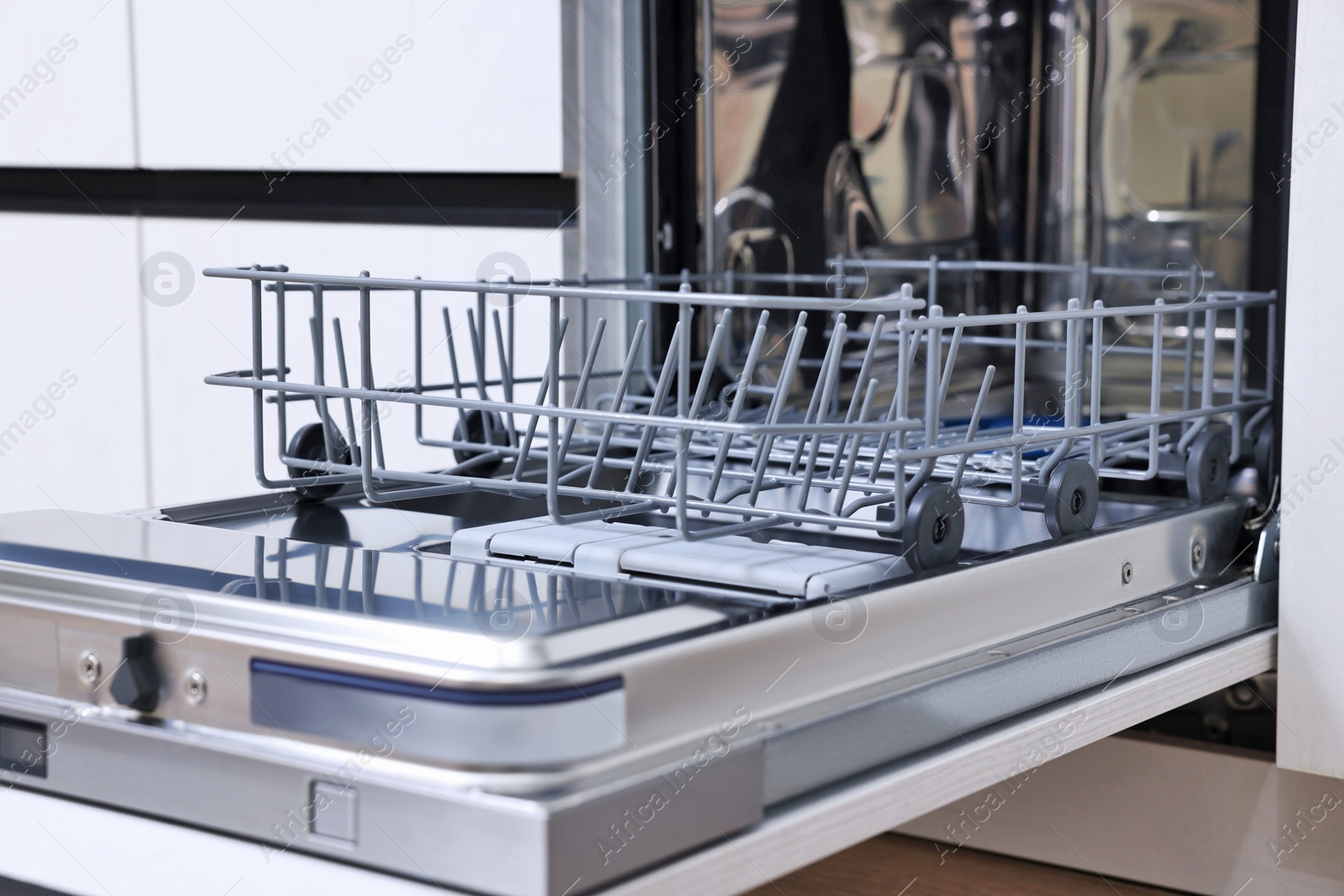 Photo of Open clean empty dishwasher indoors. Home appliance