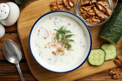 Photo of Delicious cold summer soup on wooden board, flat lay