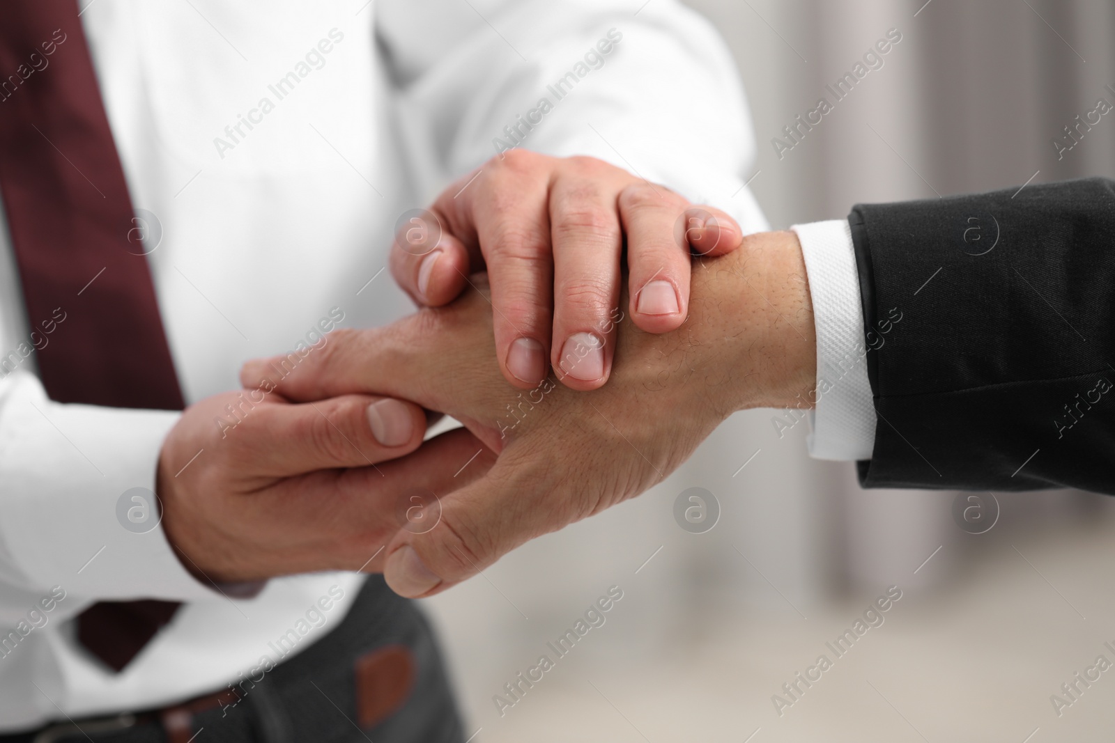 Photo of Trust and deal. Men joining hands indoors, closeup