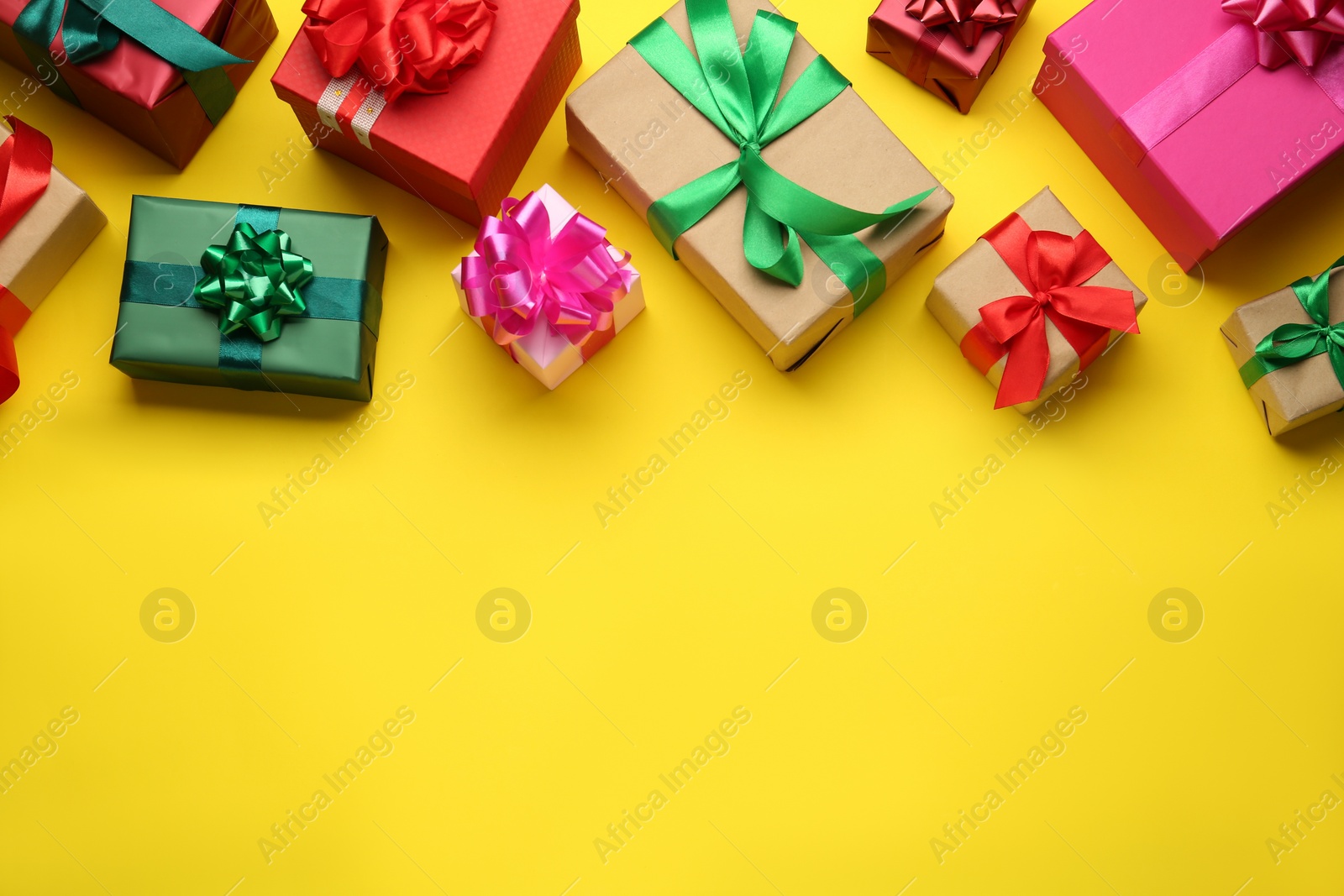 Photo of Many colorful gift boxes on yellow background, flat lay. Space for text