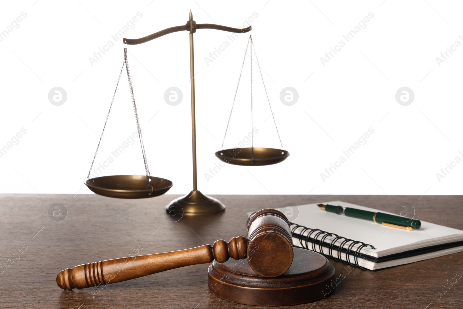 Photo of Law concept. Gavel, scales of justice, notebook and pen on wooden table against white background