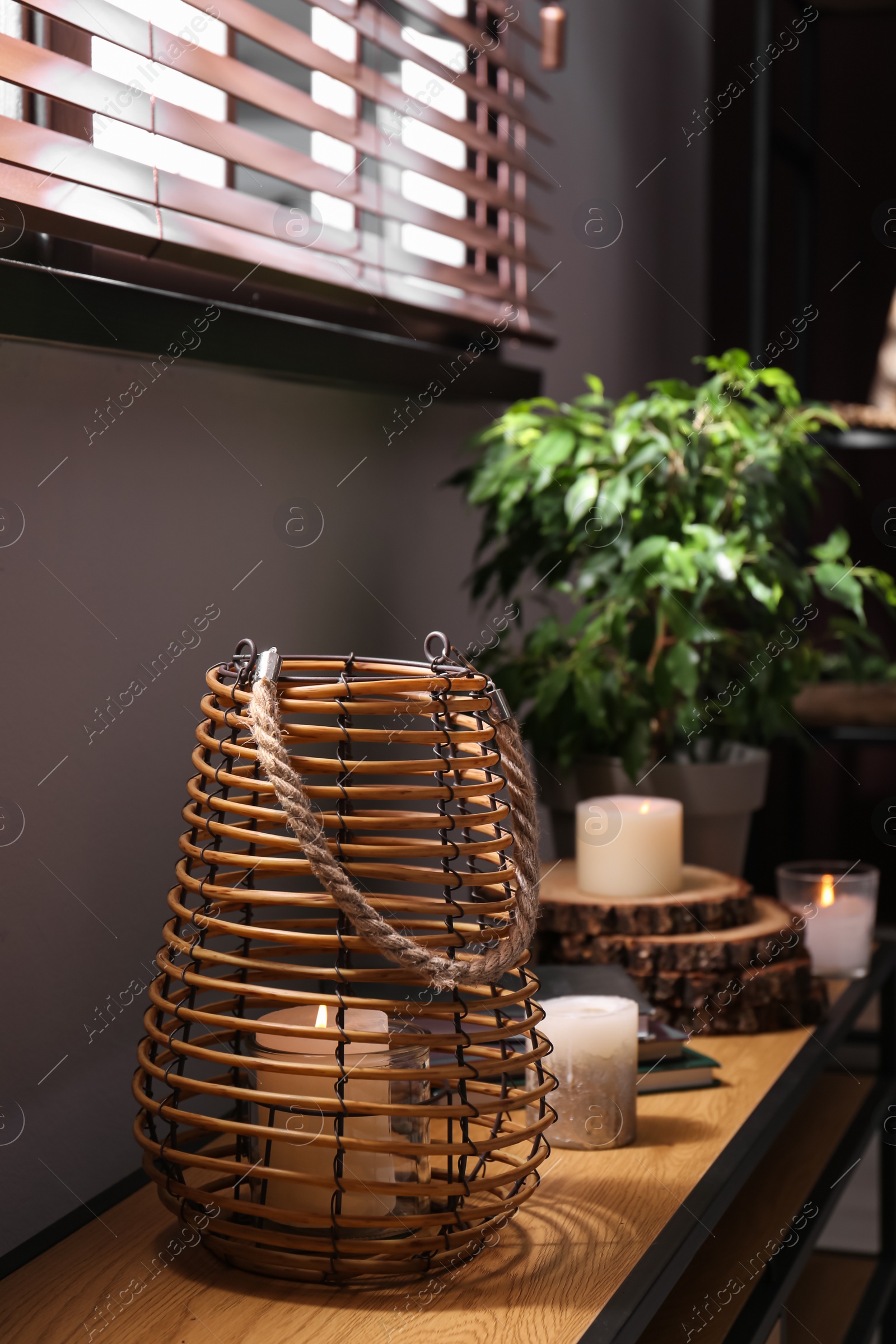 Photo of Burning scented candles on wooden console table in room