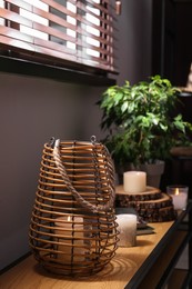 Burning scented candles on wooden console table in room